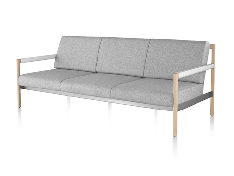 An angled view of a light gray Brabo sofa with wood legs and white arms. An angled view of a light gray Brabo sofa with wood legs and white arms.