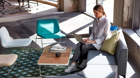 A lady sitting on Symbol Modular Seating, using a laptop. A lady sitting on Symbol Modular Seating, using a laptop.