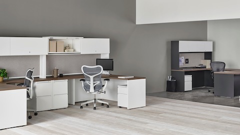 A pair of white Canvas Metal Desks with storage hutches, gray Mirra 2 Chairs, and a dark grey private office in the background. A pair of white Canvas Metal Desks with storage hutches, gray Mirra 2 Chairs, and a dark grey private office in the background.