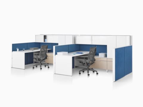 A Canvas Wall workstation with blue panels, white overhead storage, and dark grey Cosm office chairs. A Canvas Wall workstation with blue panels, white overhead storage, and dark grey Cosm office chairs.