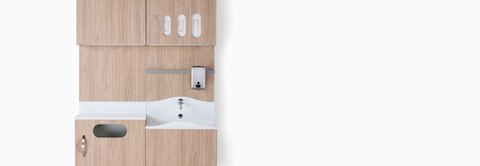 Compass System in a medium wood finish with white Corian sink and surface, trash bin, and upper storage with glove storage. our-values