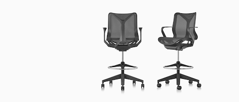 Two low-back Cosm Stools in Graphite dark gray, one viewed from the back, one viewed from an angle. Two low-back Cosm Stools in Graphite dark gray, one viewed from the back, one viewed from an angle.