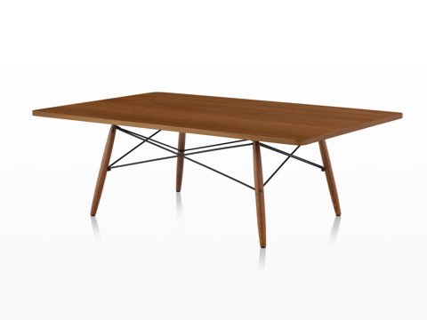 An angled view of a rectangular Eames Coffee Table with wood legs, metal cross-struts, and a medium wood top. An angled view of a rectangular Eames Coffee Table with wood legs, metal cross-struts, and a medium wood top.