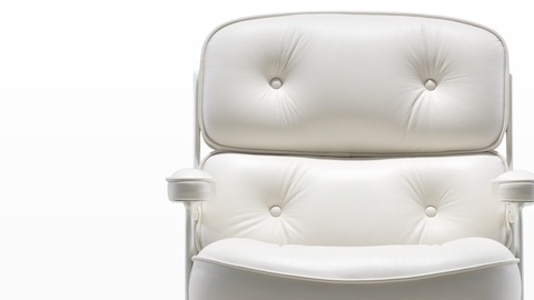 Close-up of the button detail on the plush back cushion of a white leather Eames Executive Chair. Close-up of the button detail on the plush back cushion of a white leather Eames Executive Chair.