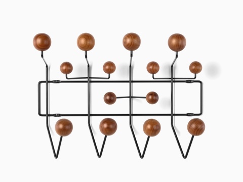 An Eames Hang-It-All storage rack, featuring a black wire frame and wood knobs in a medium finish. An Eames Hang-It-All storage rack, featuring a black wire frame and wood knobs in a medium finish.