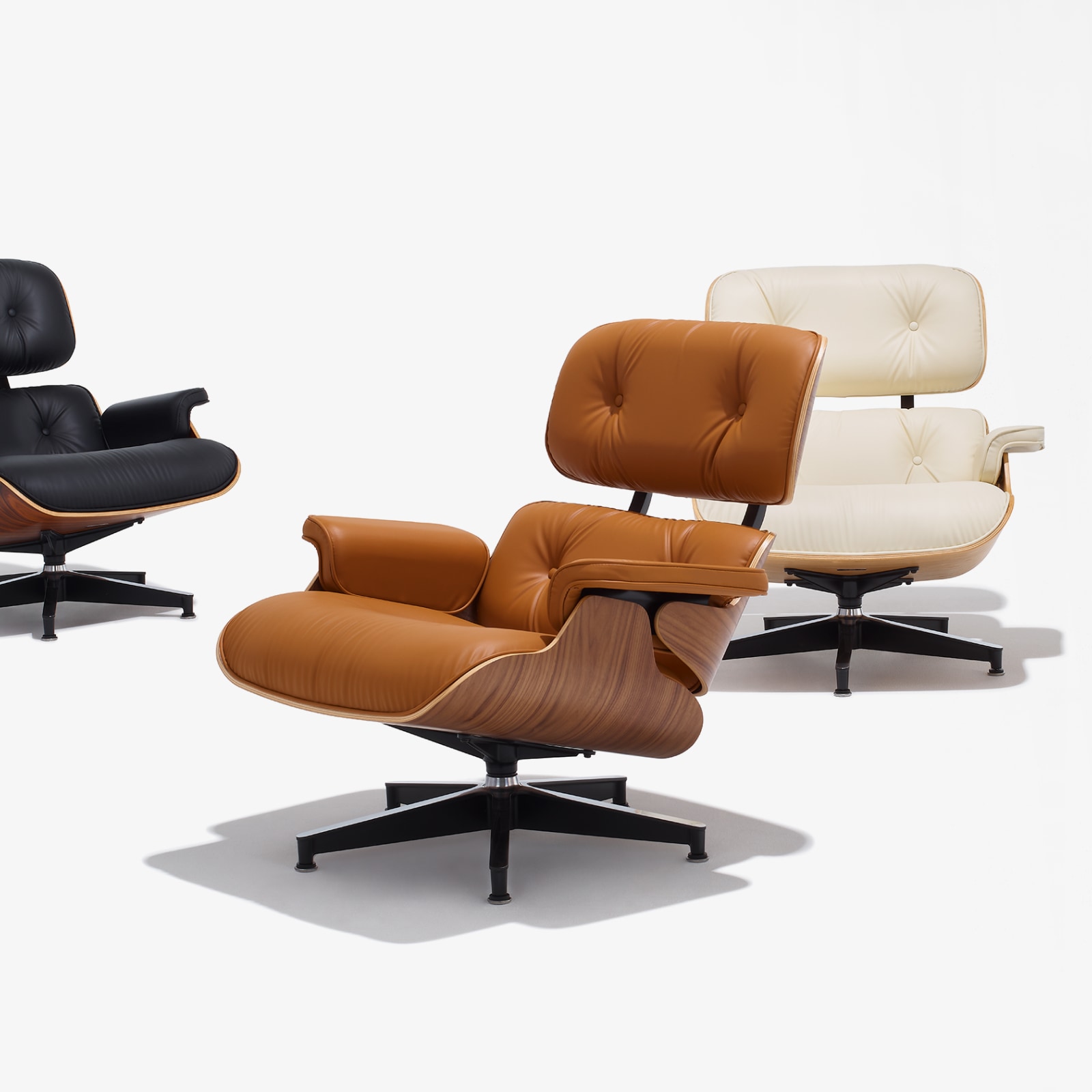 Eames Lounge Chairs in black, russet, and ivory bamboo upholstery. Eames Lounge Chairs in black, russet, and ivory bamboo upholstery.
