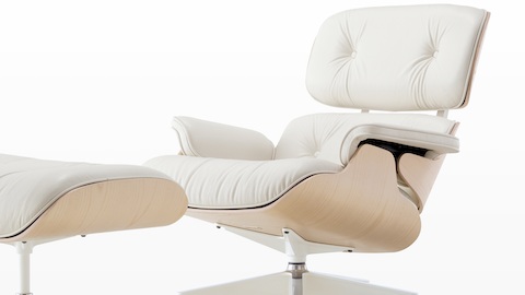 White leather Eames Lounge Chair and Ottoman with a white ash veneer shell, viewed from a 45-degree angle. White leather Eames Lounge Chair and Ottoman with a white ash veneer shell, viewed from a 45-degree angle.