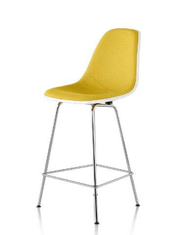 White Eames Molded Fiberglass Stool with yellow upholstery, viewed from a 45-degree angle. White Eames Molded Fiberglass Stool with yellow upholstery, viewed from a 45-degree angle.