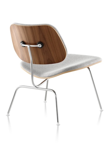 Three-quarter rear view of a gray-upholstered Eames Molded Plywood Chair with chrome-plated legs. Three-quarter rear view of a gray-upholstered Eames Molded Plywood Chair with chrome-plated legs.