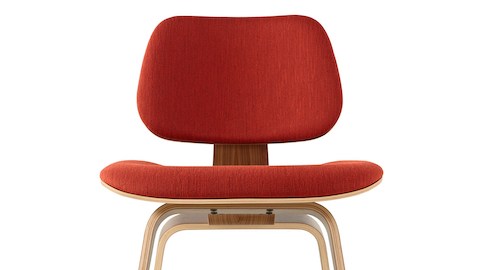 Close view of the upper half of an Eames Molded Plywood Chair with red upholstery. Close view of the upper half of an Eames Molded Plywood Chair with red upholstery.