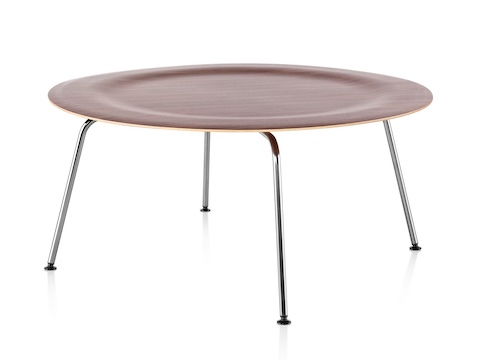 A round Eames Molded Plywood Coffee Table with metal legs and an indented top in a medium finish. A round Eames Molded Plywood Coffee Table with metal legs and an indented top in a medium finish.