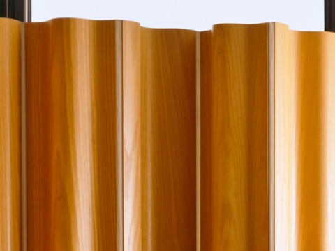 The upper portion of an Eames Molded Plywood Folding Screen in a medium wood finish. The upper portion of an Eames Molded Plywood Folding Screen in a medium wood finish.