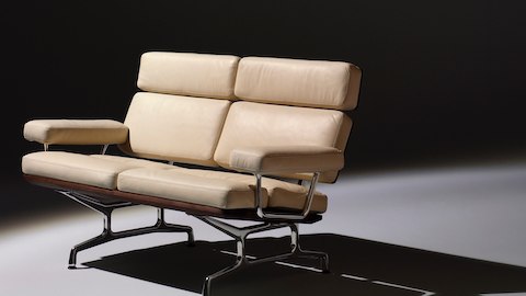 Angled view of an ivory-colored Eames loveseat, showing the thick cushions on the seat, back, and arms. Angled view of an ivory-colored Eames loveseat, showing the thick cushions on the seat, back, and arms.