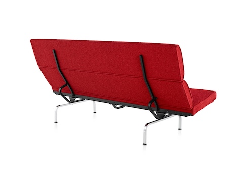 Three-quarter rear view of a red Eames Sofa Compact. Three-quarter rear view of a red Eames Sofa Compact.