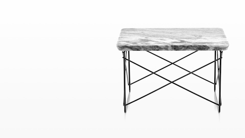 An Eames Wire Base Low Table with a stone top. An Eames Wire Base Low Table with a stone top.