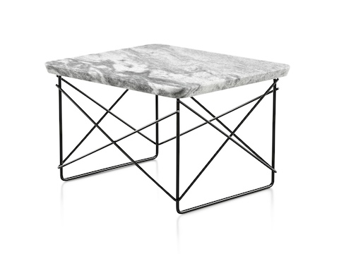 An angled view of a rectangular Eames Wire Base Low outdoor table with a marble top and black wire base. An angled view of a rectangular Eames Wire Base Low outdoor table with a marble top and black wire base.