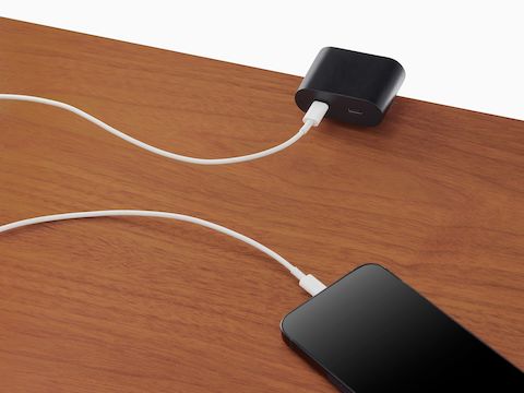 Ello Mini surface clamp USB-C power solution shown in black charging a phone. Ello Mini surface clamp USB-C power solution shown in black charging a phone.