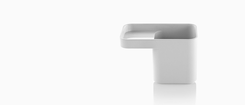 Profile view of a white Formwork Pencil Cup with a deep rear compartment and cantilevered front compartment. Profile view of a white Formwork Pencil Cup with a deep rear compartment and cantilevered front compartment.