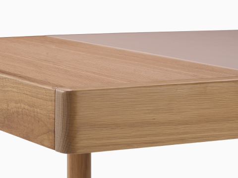Close-up view of a Leatherwrap Sit-to-Stand Desk in oak and champagne leather showing the seamless blending of Leather, Solid Wood, and Veneer. Close-up view of a Leatherwrap Sit-to-Stand Desk in oak and champagne leather showing the seamless blending of Leather, Solid Wood, and Veneer.