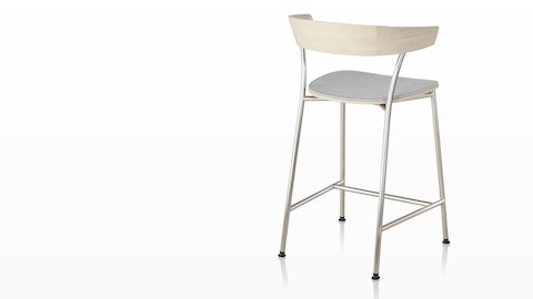 A Leeway Stool with light metal base, light wood backrest, and upholstered seat, viewed from the rear. A Leeway Stool with light metal base, light wood backrest, and upholstered seat, viewed from the rear.