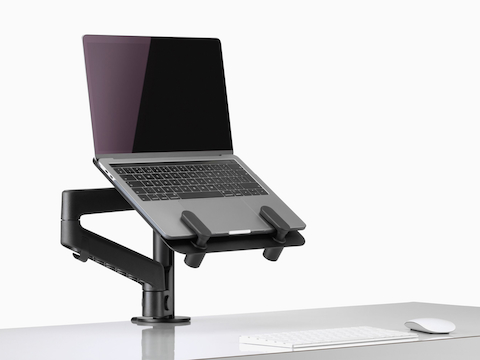 Side angle view of an open laptop raised from a desk and supported by a black Lima Laptop Mount and Lima Monitor Arm. Side angle view of an open laptop raised from a desk and supported by a black Lima Laptop Mount and Lima Monitor Arm.