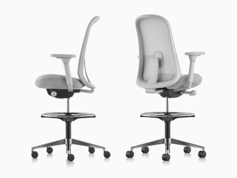 Two light gray Lino Stools with adjustable sacral lumbar support, viewed from the side and from the back at an angle. Two light gray Lino Stools with adjustable sacral lumbar support, viewed from the side and from the back at an angle.