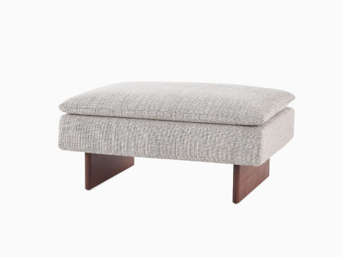 Angled view of a Mantle Ottoman upholstered in Capri Stone wit a Walnut Wood Base. Angled view of a Mantle Ottoman upholstered in Capri Stone wit a Walnut Wood Base.