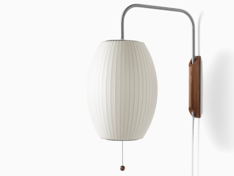 A Nelson Cigar Wall Sconce with a swivel arm and walnut wall mount. A Nelson Cigar Wall Sconce with a swivel arm and walnut wall mount.
