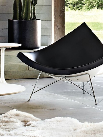 A black leather Nelson Coconut Lounge Chair on an outdoor patio. A black leather Nelson Coconut Lounge Chair on an outdoor patio.