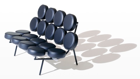 A black leather Nelson Marshmallow Sofa, viewed from a 45-degree angle that includes its shadow. A black leather Nelson Marshmallow Sofa, viewed from a 45-degree angle that includes its shadow.