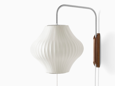A Nelson Pear Wall Sconce with a swivel arm and walnut wall mount. A Nelson Pear Wall Sconce with a swivel arm and walnut wall mount.