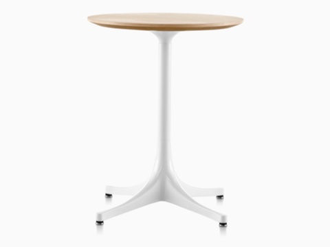 A round Nelson Pedestal Table with a light woodgrain top and white base. A round Nelson Pedestal Table with a light woodgrain top and white base.