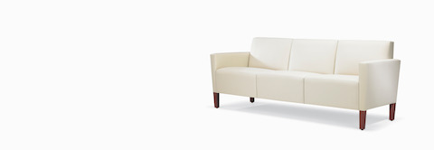 A Brava Classic Lounge Sofa with white textile and upholstered arm caps. A Brava Classic Lounge Sofa with white textile and upholstered arm caps.