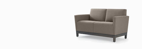 Three-quarter view of a gray two-seat Brava Platform Lounge on wood base. Three-quarter view of a gray two-seat Brava Platform Lounge on wood base.