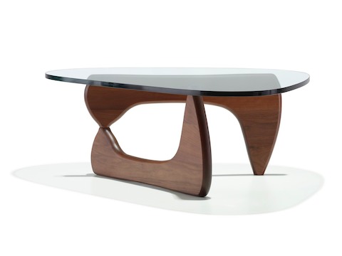 A Noguchi occasional table with a freeform glass top and curved wood base in a medium finish. A Noguchi occasional table with a freeform glass top and curved wood base in a medium finish.