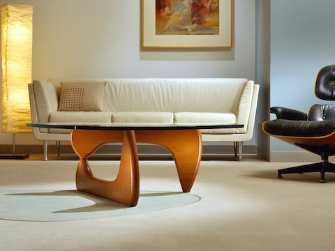 A Noguchi occasional table complements an ivory-colored Goetz Sofa and black Eames Lounge Chair. A Noguchi occasional table complements an ivory-colored Goetz Sofa and black Eames Lounge Chair.