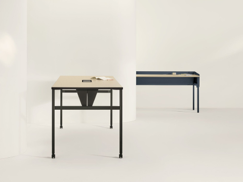 Two OE1 Communal Tables with light brown surfaces and black and blue finishes, viewed from side and front angles. Two OE1 Communal Tables with light brown surfaces and black and blue finishes, viewed from side and front angles.