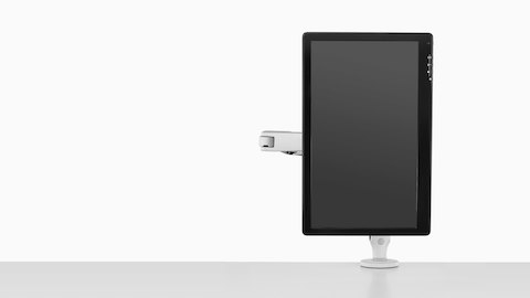 Front view of a monitor suspended in portrait orientation by a single light gray Ollin Monitor Arm. Front view of a monitor suspended in portrait orientation by a single light gray Ollin Monitor Arm.