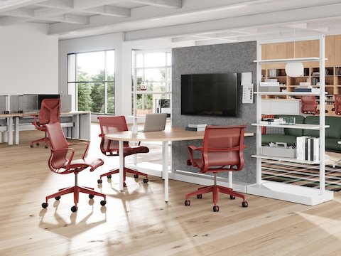 A workplace neighborhood that features red Setu Chairs and Stools, a variety of flexible work points, a focused space, and a lounge area. A workplace neighborhood that features red Setu Chairs and Stools, a variety of flexible work points, a focused space, and a lounge area.