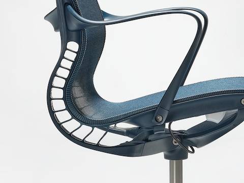 A close-up side view of a Setu chair with arms in nightfall blue. A close-up side view of a Setu chair with arms in nightfall blue.