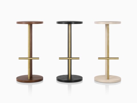 Three Spot Stools of different heights, featuring a circular seat and base connected by two parallel legs of wood and metal. Three Spot Stools of different heights, featuring a circular seat and base connected by two parallel legs of wood and metal.