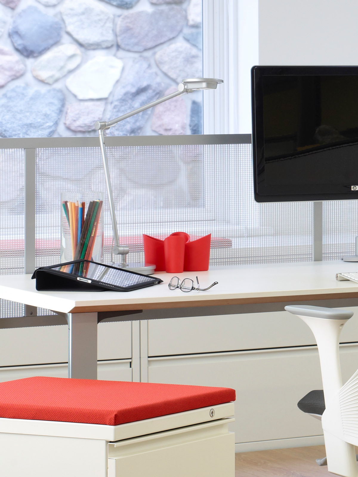 A desktop supports a computer, organizers, and a space-saving Tone Personal Light. A desktop supports a computer, organizers, and a space-saving Tone Personal Light.