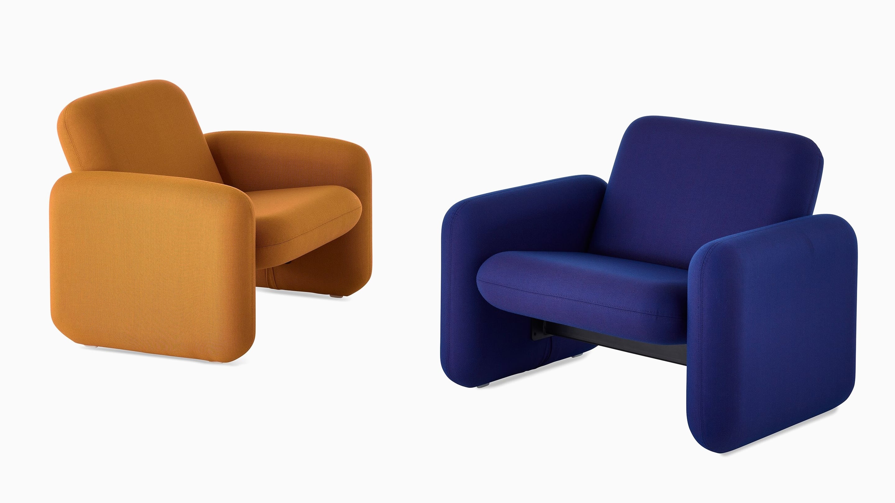 Two Wilkes Modular Sofa Group Chairs facing each other at an angle. The chair on the left is dark yellow and the chair on the right is blue. Two Wilkes Modular Sofa Group Chairs facing each other at an angle. The chair on the left is dark yellow and the chair on the right is blue.