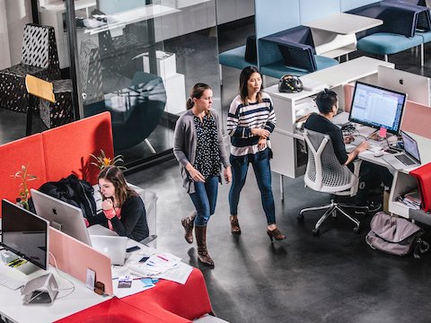 Office employees work and talk amidst an open office design. Office employees work and talk amidst an open office design.