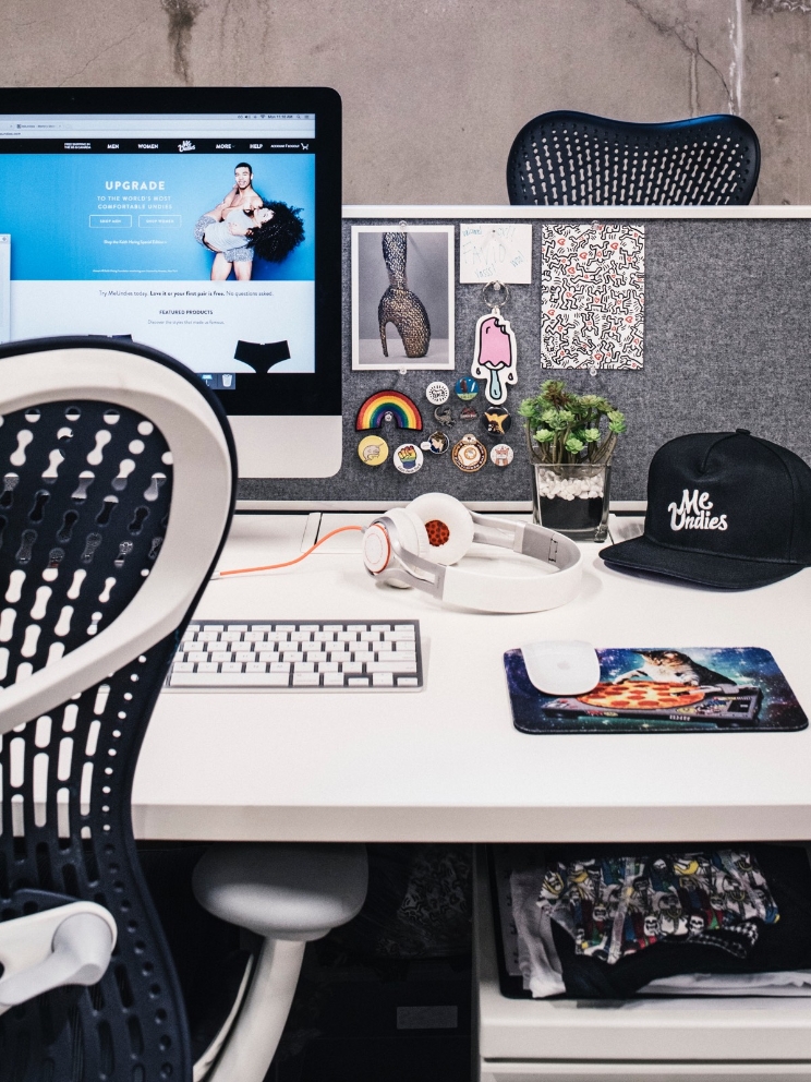 An office desk setup shows a computer and various personal items as decor. An office desk setup shows a computer and various personal items as decor.