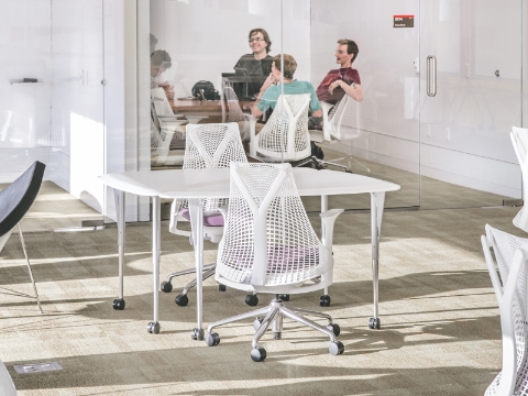Students converse while in an enclosed room within a campus library. Students converse while in an enclosed room within a campus library.