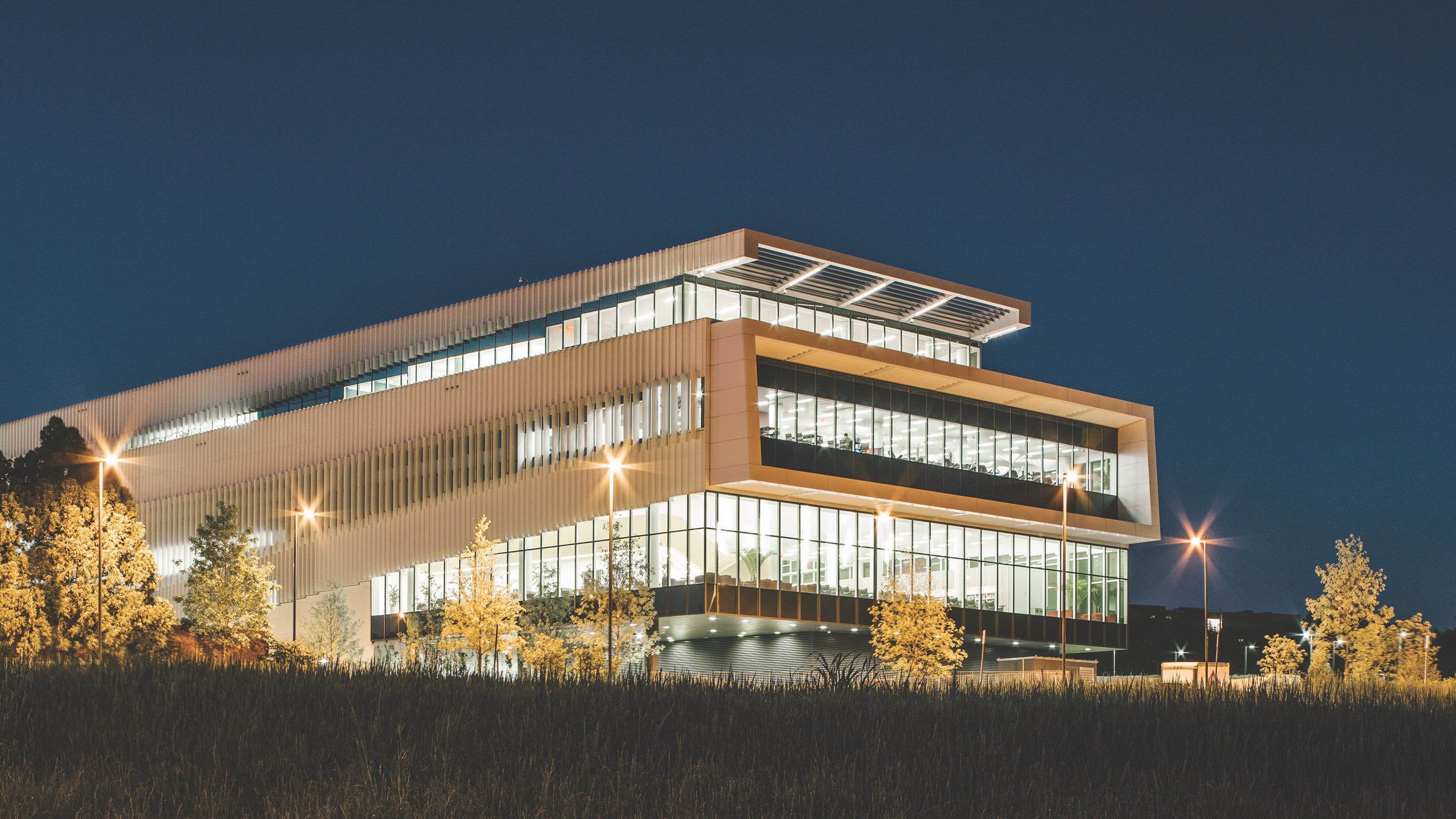 An exterior view of a campus library at night. An exterior view of a campus library at night.