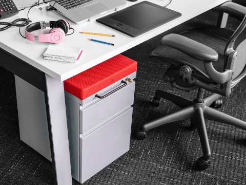 A desk setup with a laptop, pencils, headphones, and a notepad sitting out. A desk setup with a laptop, pencils, headphones, and a notepad sitting out.