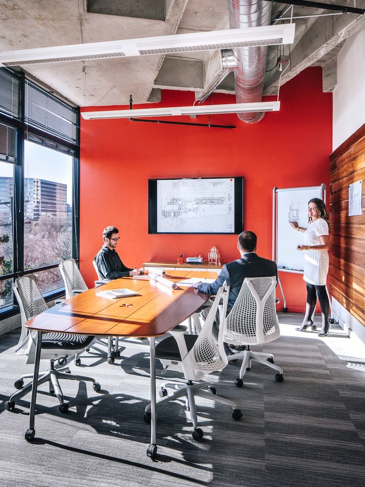 Employees converse inside of a conference room while seated in Sayl chairs. Employees converse inside of a conference room while seated in Sayl chairs.