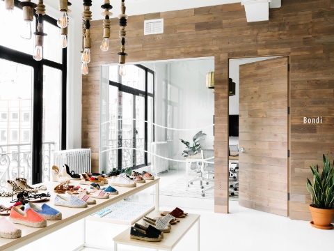 Rows of shoes sit on tables outside of an office entrance. Rows of shoes sit on tables outside of an office entrance.